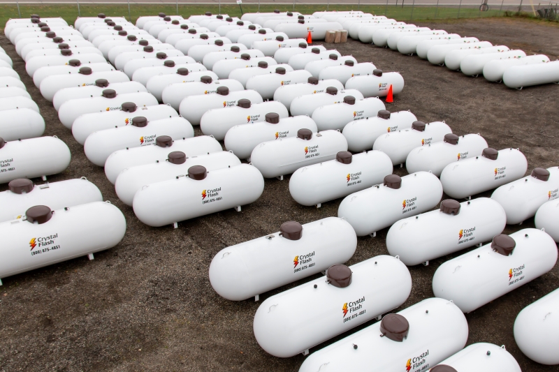 Many propane tanks lined up in lot